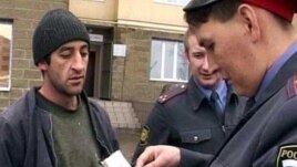 Полицейский в России проверяет документы трудовых мигрантов из Таджикистана.
