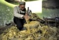 Many Kashgar residents live traditional lives. Here, a man crafts Uyghur instruments.