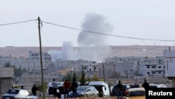Smoke rises after a mortar lands in the Syrian town of Kobani, near the Turkish border, which has been besieged by Islamic State insurgents in recent days.