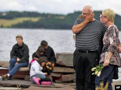 Ljudi i rođaci žrtava okupljeni tokom minute ćutanja u kampu Utoya, Norveška, 25. jul 2011.
