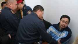 Полицейлер Ермек Нарымбаевты сот залынан әкетіп барады. Алматы, 14 маусым 2010 жыл.