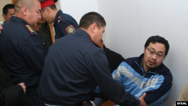 Полицейлер Ермек Нарымбаевты сот залынан әкетіп барады. Алматы, 14 маусым 2010 жыл.