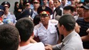 Полицейские сдерживают толпу родственников заключенных алматинской тюрьмы, которые требовали встречи с родными. Алматы, 30 июля 2010 года.