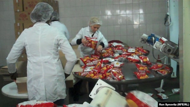Workers pack the finished product at the Pestova potato-chip factory north of Pristina, one of Kosovo's few production success stories.