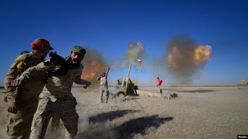 Shi'ite fighters fire artillery toward Islamic State militants during a battle on the outskirt of Tal Afar, west of Mosul, on November 18.