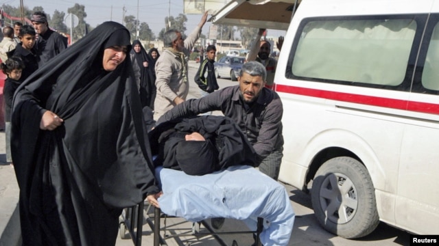 Residents wheel a stretcher carrying a wounded woman after a bomb attack targeted Shi'ite pilgrims commemorating a religious ceremony in Karbala.