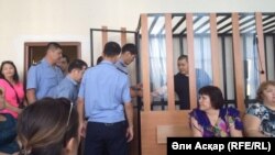 "WhatsApp желісінде терроризмді насихаттады" деп айыпталып, сотталушылар (артқы жақта торда) мен олардың адвокаттары (алдыңғы қатарда отырған). Ақтөбе, 11 тамыз 2016 жыл.