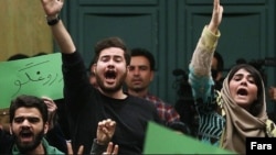 Iranian students holding handwritten signs in green – the color of the opposition movement -- chanted in protest during a speech by Hossein Shariatmadari, the editor of the ultra-hard-line daily "Kayhan."