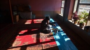 A Hazara tribesman talks on his phone as he eats at a traditional restaurant in Bamiyan, Afghanistan. (AFP/Massoud Hossaini)