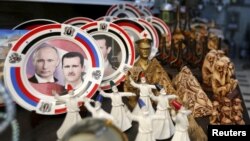 Souvenir plates depicting Syrian President Bashar al-Assad and Russian President Vladimir Putin are seen among other items for sale in old Damascus. How closely the two are coordinating future plans is hard to guess, however.