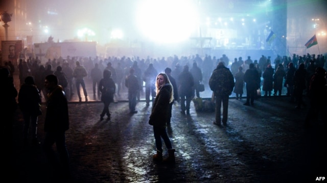 Ուկրաինա - Մարդիկ լրատվական հաղորդում են դիտում Կիևի Անկախության հրապարակում՝ Եվրոմայդանում տեղադրված մեծ էկրանին, 4-ը մարտի, 2014թ․  Ukraine -- A woman looks on as people watch news on a large TV screen at the Independence square in central Kyiv, March 4, 2014