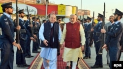 Indian Prime Minister Narendra Modi (center right) is welcomed by his Pakistani counterpart Nawaz Sharif at Lahore airport on December 25.
