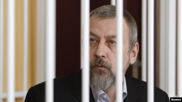 Former opposition presidential candidate Andrey Sannikau sits in a cage during a court hearing in Minsk in April.