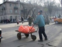 A boy guides his cart across a street near a Kyrgyz market (RFE/RL)