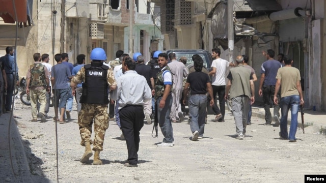 UN observers inspect a residential area with Free Syrian Army gunmen in the Talbisah area of Homs.