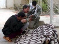 Iraqis grieve over a dead relative, killed in Ba'qubah on December 13 (epa)