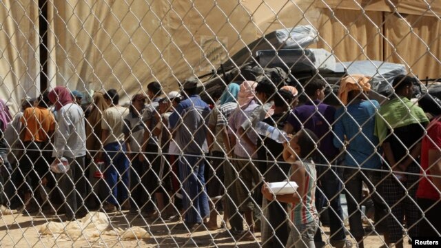 Syrian refugees wait to receive aid and rations at the Zaatri refugee camp in the city of Mafraq, Jordan, on September 5.