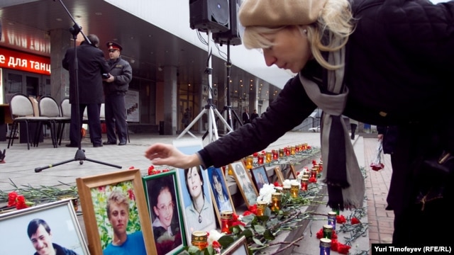 A woman looks at photographs of victims at a commemoration ceremony recalling the Dubrovka theater in Moscow, which resulted in 130 deaths.