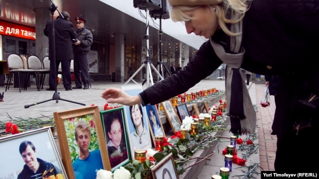 A woman places a photo at a commemoration ceremony for the victims at the Dubrovka Theater in Moscow on the event's ninth anniversary on October 26.