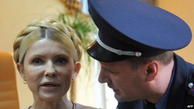 A police officer tries to calm Yulia Tymoshenko as she reacts to the verdict.