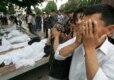 People pray near the bodies of victims after the crackdown