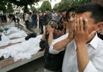 Andijon residents pray in front of the bodies of victims of the government crackdown in May 2005 (file photo) (epa)