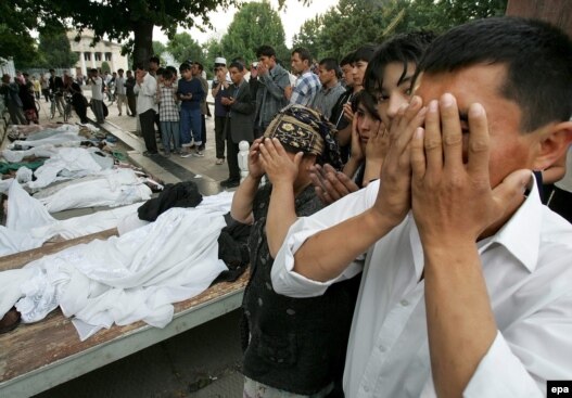 People pray on May  14, 2005, by the bodies of victims of the government crackdown in  Andijon.