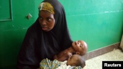 A Somalian woman holds a malnourished baby in Banadir hospital in Mogadishu.