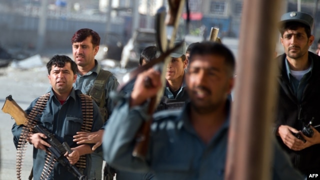 Afghan security personnel work at the scene of an attack in Kabul in May.