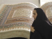 Iran - A woman passes by a sculpture of an open holy Koran during the annual Koran exhibition in Tehran, 17Sep2007