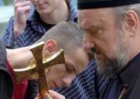 Serbian Orthodox priest praying at the Srebrenica cemetery, July 2005 (epa)
