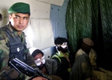 Afghanistan -- Afghan Nat'l Army soldier escorts Pakistani and Afghan self-confessed Taliban prisoners, 18Oct2006