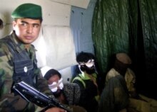 Afghanistan -- Afghan Nat'l Army soldier escorts Pakistani and Afghan self-confessed Taliban prisoners, 18Oct2006