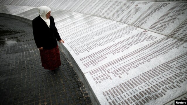 A Bosnian woman looks for the names of her dead relatives on a memorial plaque to the roughly 8,000 men and boys killed at Srebrenica.