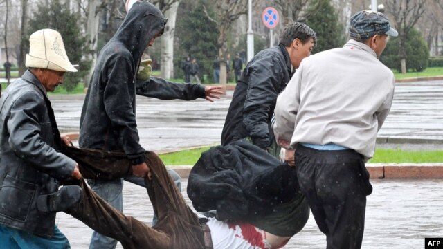 Protesters carry a victim of the security forces' crackdown on the crowd outside the main government building in Bishkek on April 7, 2010, when officials say 87 people died.