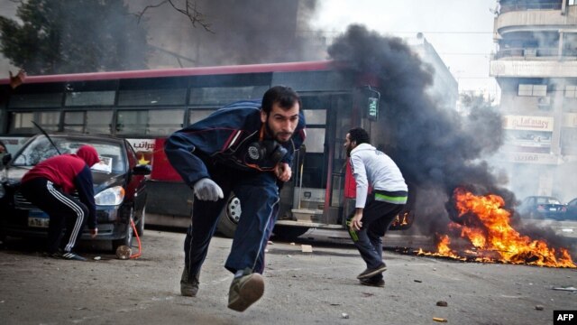 Supporters of Egypt's deposed President Muhammad Morsi run for cover from tear gas fired by riot police during clashes in the northeastern part of Cairo's Nasr City district on January 3.