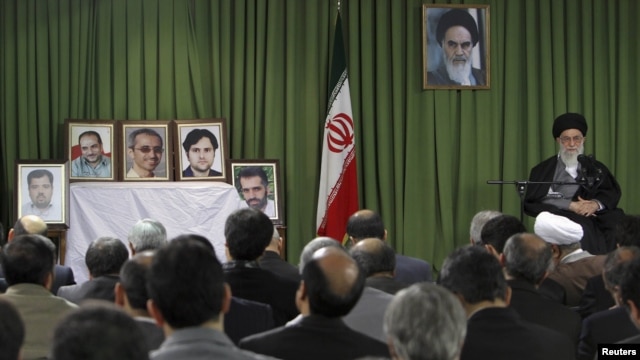 Iranian Supreme Leader Ayatollah Ali Khamenei (right) attends a meeting in February in Tehran with Iranian nuclear scientists and managers as portraits of recently slain Iranian scientists are displayed.