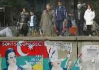 Baku residents pass by campaign posters today (AFP)