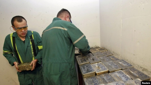 Workers stack gold bars in the safe at the Kumtor goldmine in Kyrgyzstan