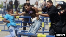 An anti-Mubarak demonstrator is detained by riot police after clashes with pro-Mubarak demonstrators and riot policemen in September in front of the police academy where former President Hosni Murbarak was on trial in Cairo.