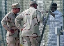 Cuba/U.S. -- US guards and a prisoner at Guantanamo's Naval Base, 15 Feb. 2006