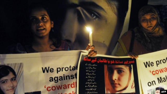 Pakistani civil society activists carry candles to pay tribute to Malala Yousafzai in Lahore.