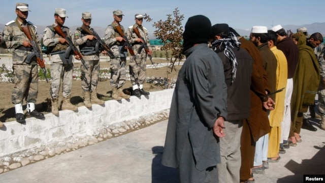 Taliban militants who were arrested by Afghan police stand during a presentation of seized weapons and equipment in Jalalabad on March 2.