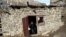 An old woman throws dirty water out of her house in Khyurdabakh, in the mountains of Daghestan. Patimat Musalmagomedova is the last permanent resident of the village.