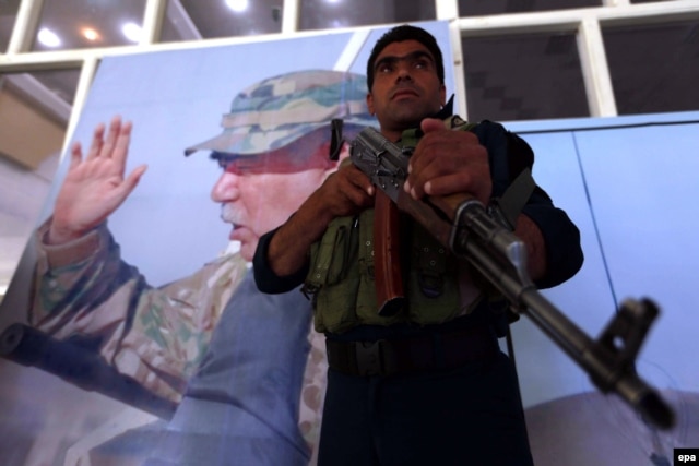 Афганский солдат стоит на фоне портрета вице-президента Афганистана Абдула Рашида Дустума. Герат, 30 августа 2015 года.