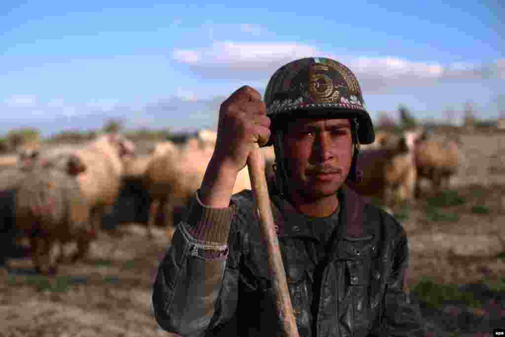A Syrian shepherd with a military-style helmet on the outskirts of Damascus. (epa/Mohammed Badra)