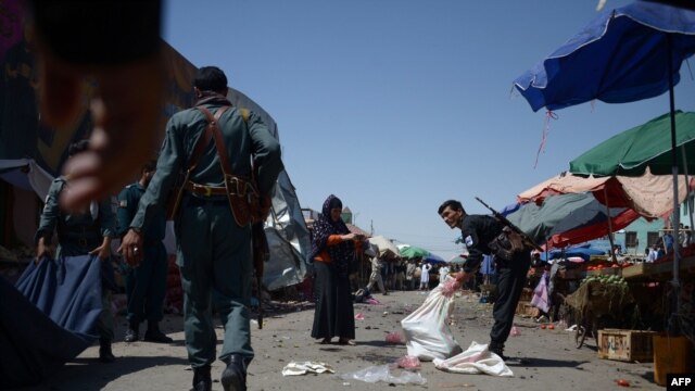 Afghan policemen investigate at the site of an attack after a suicide bomber blew himself up at a crowded marketplace in Mazar-e Sharif on August 9.