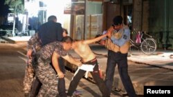 Iraqi security forces remove a suicide vest from a boy in Kirkuk on August 21.