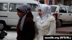 According to Uzbek authorities, if a head scarf is tied behind the head (like that of the woman on the left) that is socially acceptable. If the head scarf is tied under the chin that like that of the woman on the right, it is deemed to be offensive. (file photo)