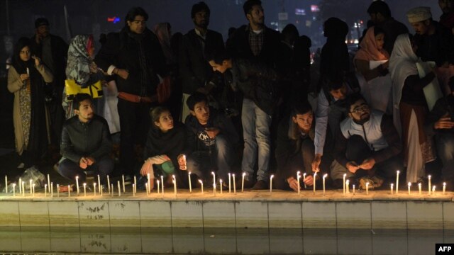 Pakistani civil society activists place lit candles during a vigil in Lahore on December 18 for the children and teachers killed in an attack by militants on an army-run school in Peshawar.